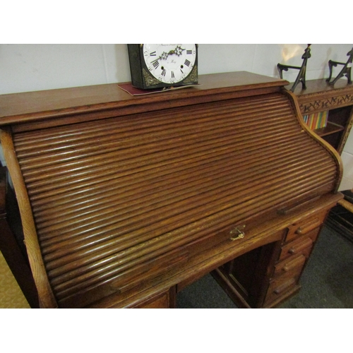 1013 - A Circa 1900 oak roll top desk with key, 119cm high x 125cm wide x 75cm deep