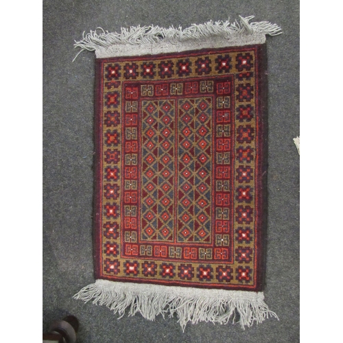 1021 - A red ground rug with tasselled ends, 160cm x 85cm, and one other, 64cm x 48cm