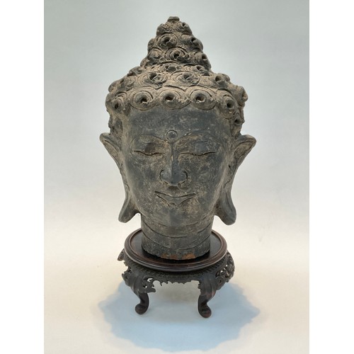 1422 - A terracotta bust of a deity on a carved wooden stand, some damage, 40cm tall total