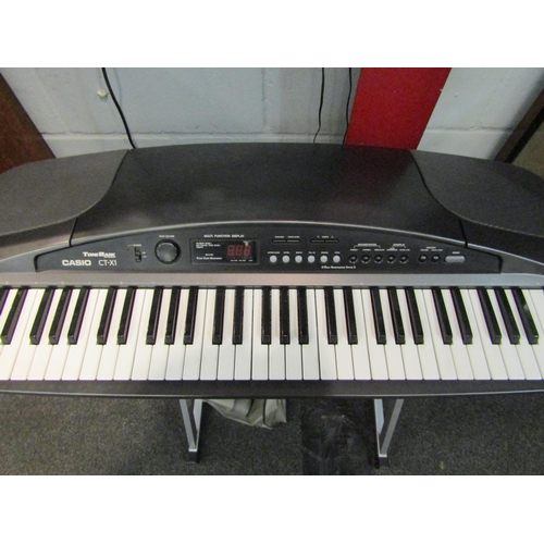 1062 - An electronic Casio CT-X1 keyboard, complete with stand and power supply