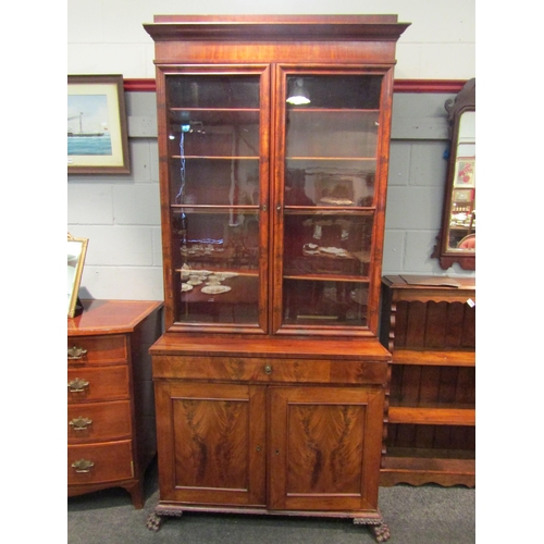 1068 - A 19th Century flame mahogany secretaire bookcase, single drawer over two cupboard doors on carved p... 