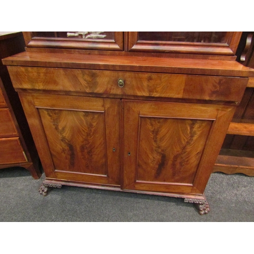 1068 - A 19th Century flame mahogany secretaire bookcase, single drawer over two cupboard doors on carved p... 