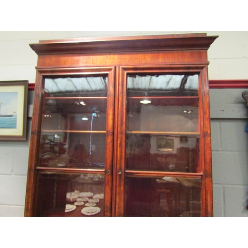 1068 - A 19th Century flame mahogany secretaire bookcase, single drawer over two cupboard doors on carved p... 