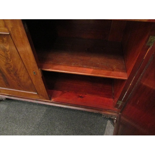 1068 - A 19th Century flame mahogany secretaire bookcase, single drawer over two cupboard doors on carved p... 