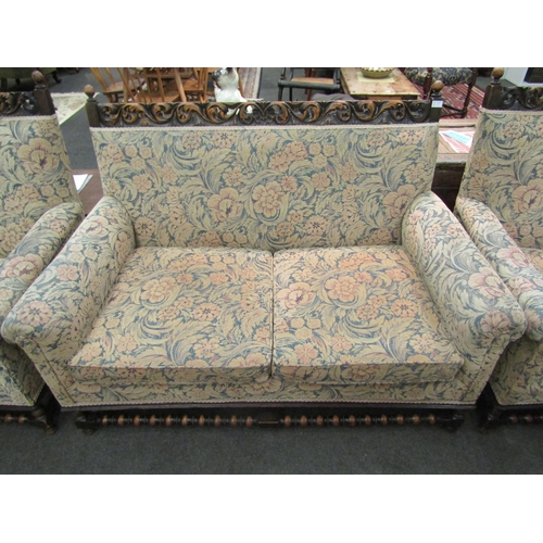 1147 - An early 20th Century oak Jacobean style three piece suite with scrolled carved back, bobbin front s... 