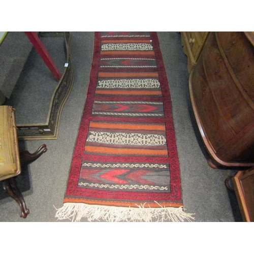 1029 - A kilim runner rug, red ground, tassels a/f, 90cm x 70cm