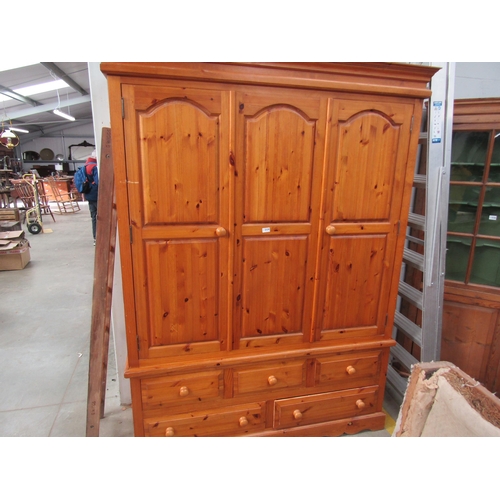 2329 - A large pine wardrobe with four drawer base