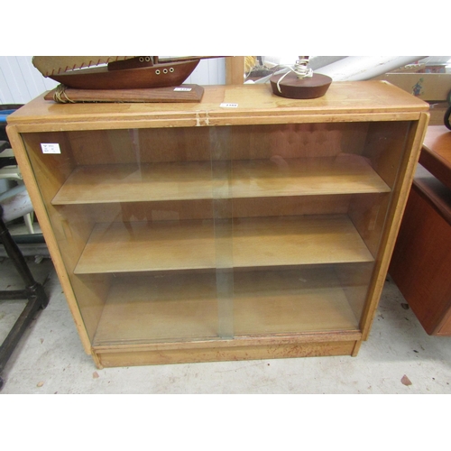 2388 - A light oak glazed sliding door bookcase