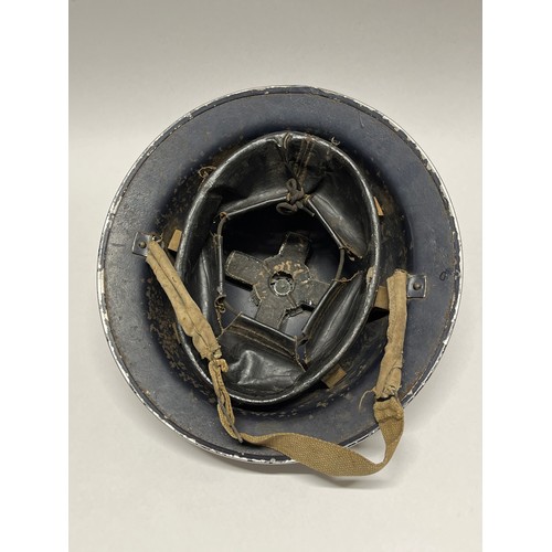 9260 - A WWII helmet painted for police use, dark blue with POLICE lettering, with liner and chinstrap, cor... 