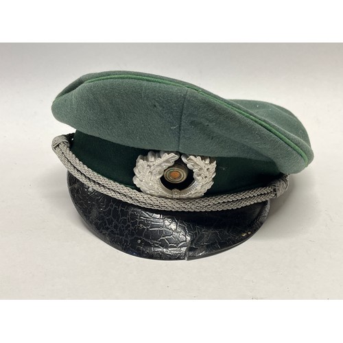 9113 - A mid 20th Century German Officer’s visor cap, signs of eagle badge having been mounted, dark green ... 