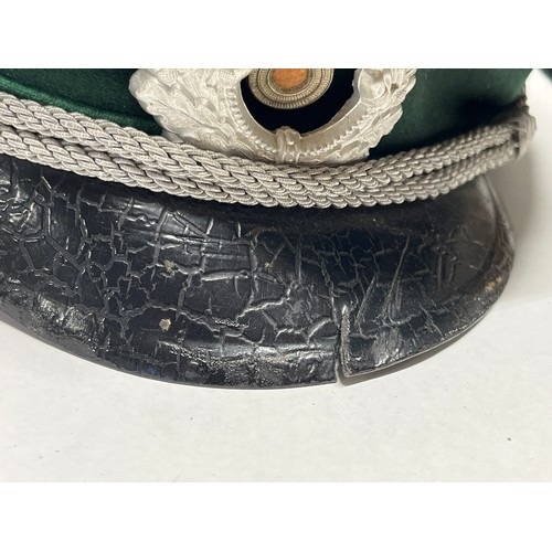 9113 - A mid 20th Century German Officer’s visor cap, signs of eagle badge having been mounted, dark green ... 