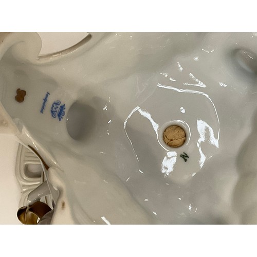 6164 - A 20th Century Dresden centre bowl held aloft by cherubs reading and playing musical instruments, pa... 