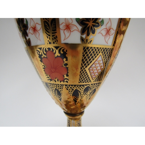 6223 - A pair of Royal Crown Derby Imari pattern urns, ovoid form with fixed knop cover and two high loop h... 