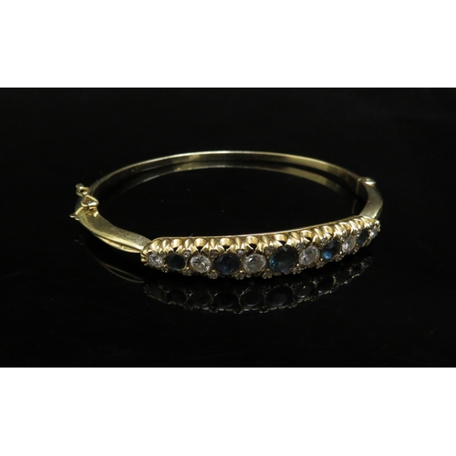 6237 - A gold stiff hinge bangle set with alternate sapphires and diamonds, 1ct approx diamond total, unmar... 