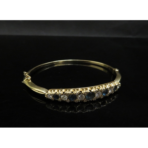 6237 - A gold stiff hinge bangle set with alternate sapphires and diamonds, 1ct approx diamond total, unmar... 