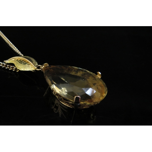 6248 - A large pear shaped citrine pendant, 4cm long in 14ct gold mount with later applied 18ct gold leaf m... 