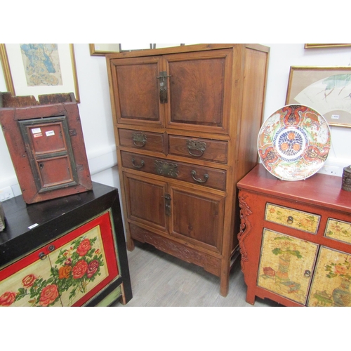 6062 - An antique Chinese cupboard with two doors above three drawers over two door base with carved frieze... 