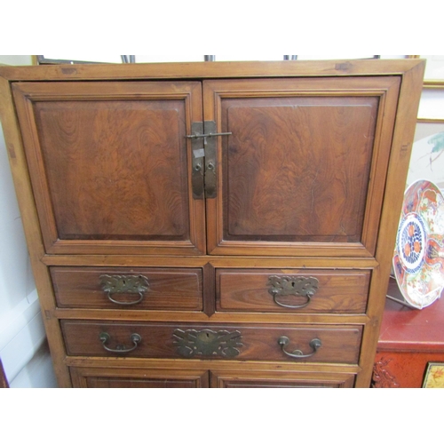 6062 - An antique Chinese cupboard with two doors above three drawers over two door base with carved frieze... 