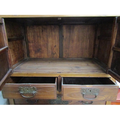 6062 - An antique Chinese cupboard with two doors above three drawers over two door base with carved frieze... 