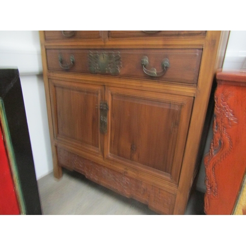 6062 - An antique Chinese cupboard with two doors above three drawers over two door base with carved frieze... 