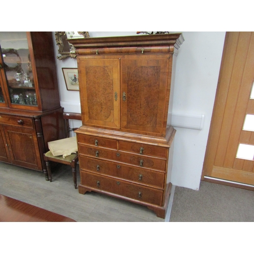 6067 - A William & Mary burr walnut veneered cabinet on chest, ogee pediment over single top drawer. The do... 