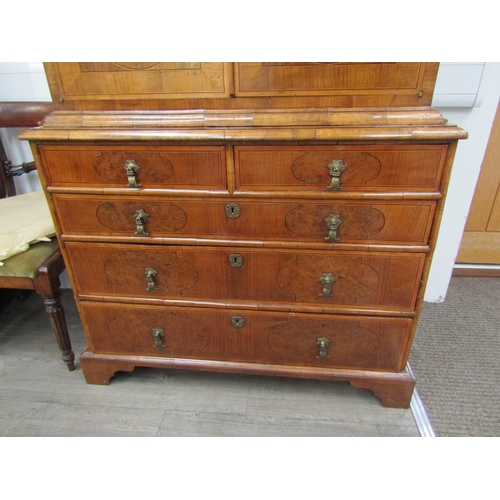 6067 - A William & Mary burr walnut veneered cabinet on chest, ogee pediment over single top drawer. The do... 