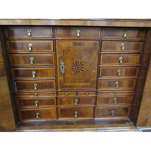 6067 - A William & Mary burr walnut veneered cabinet on chest, ogee pediment over single top drawer. The do... 
