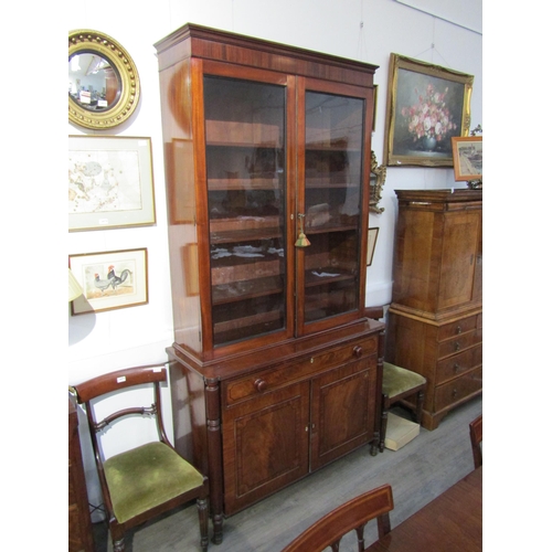 6071 - A George III mahogany two door glazed bookcase over single drawer two cupboard door base. Ebonised l... 