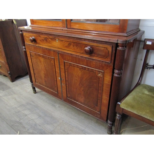 6071 - A George III mahogany two door glazed bookcase over single drawer two cupboard door base. Ebonised l... 