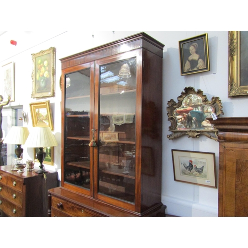 6071 - A George III mahogany two door glazed bookcase over single drawer two cupboard door base. Ebonised l... 