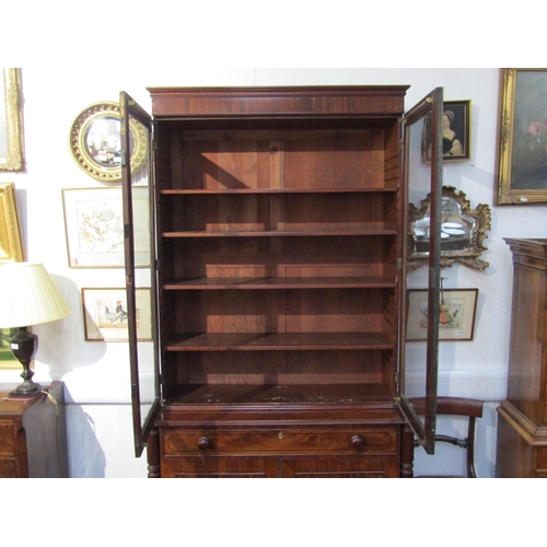 6071 - A George III mahogany two door glazed bookcase over single drawer two cupboard door base. Ebonised l... 