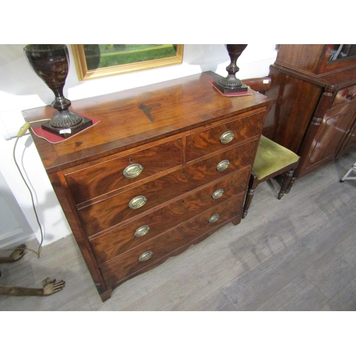 6081 - A Georgian mahogany two over three chest of drawers with oval plate handles, shaped apron, canted co... 