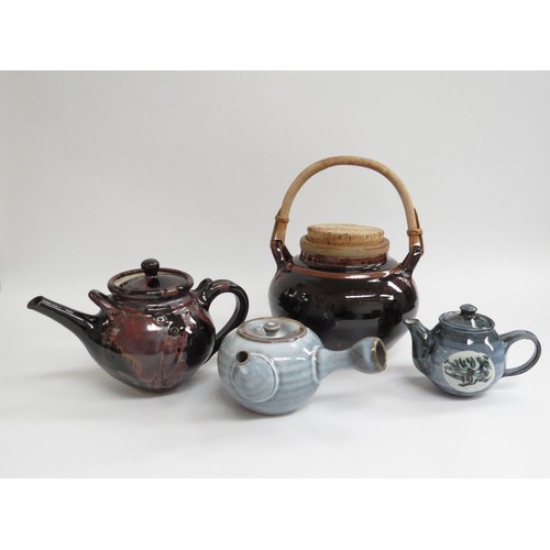 9102 - A collection of studio pottery including three teapots of various sizes and glazes and a large cane ... 