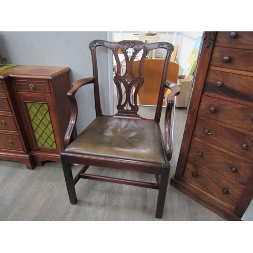 6087 - A Georgian mahogany armchair with carved acanthus leaf pierced central splat over a leather seat and... 
