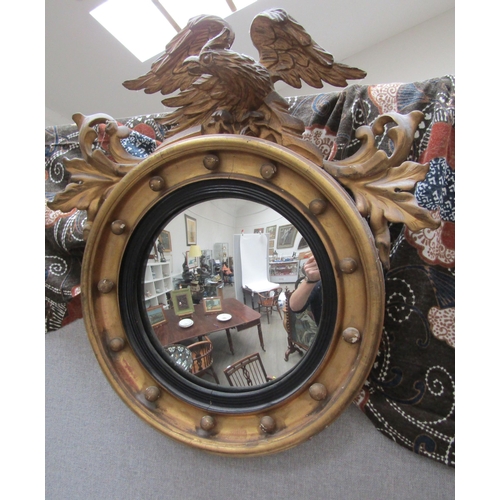 6102 - A Regency gilt circular mirror with ball detail surmounted by an eagle with acanthus leaf decoration... 