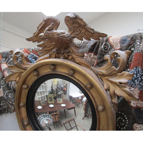 6102 - A Regency gilt circular mirror with ball detail surmounted by an eagle with acanthus leaf decoration... 