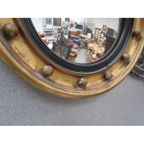 6102 - A Regency gilt circular mirror with ball detail surmounted by an eagle with acanthus leaf decoration... 