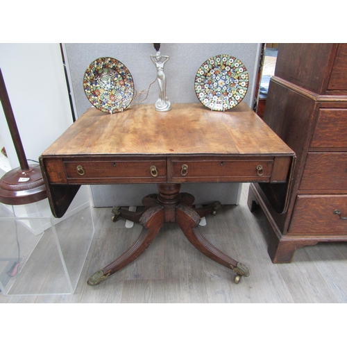 6106 - A Regency mahogany sofa table with two drawers turned stem to quatraform base, reeded legs to cup ca... 