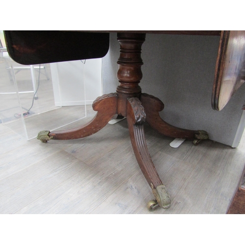 6106 - A Regency mahogany sofa table with two drawers turned stem to quatraform base, reeded legs to cup ca... 