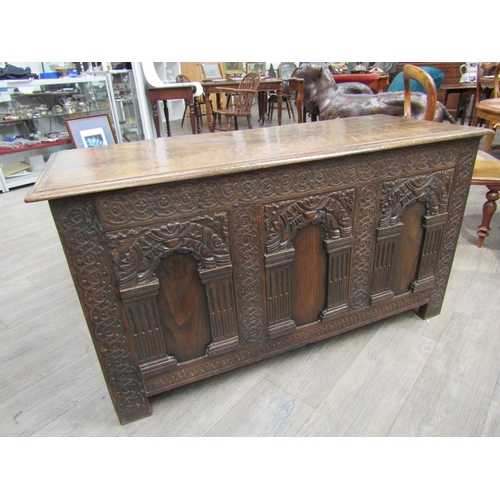 6182 - A late 18th/19th Century oak coffer with carved conjoining rosette borders, the three front panels w... 