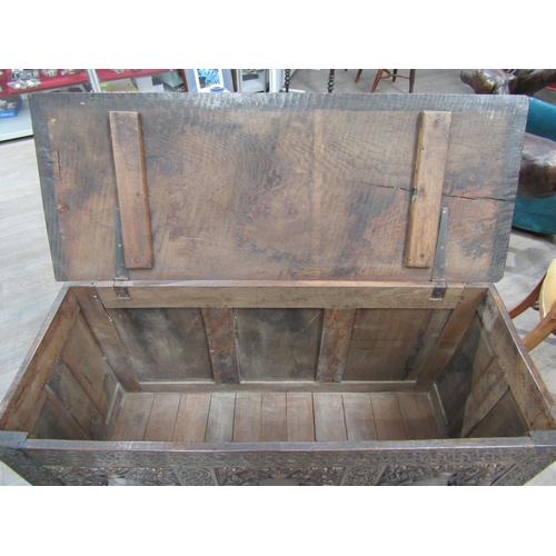 6182 - A late 18th/19th Century oak coffer with carved conjoining rosette borders, the three front panels w... 