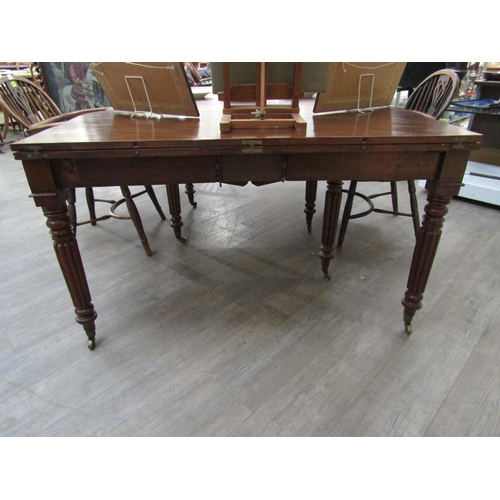 6197 - A Georgian mahogany concertina action extending dining table of rounded square form raised upon six ... 