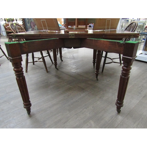 6197 - A Georgian mahogany concertina action extending dining table of rounded square form raised upon six ... 