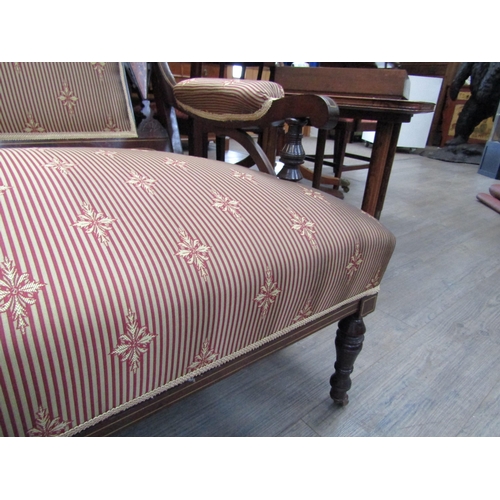 6208 - An Edwardian mahogany satinwood inlaid sofa with overstuffed striped silk upholstery, on turned supp... 