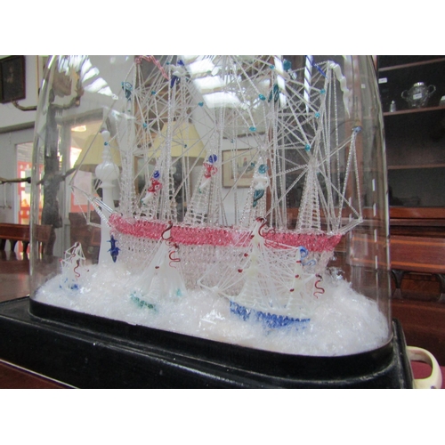 6214 - A spun glass Galleon scene with three smaller vessels and light house, under glass dome, dome measur... 