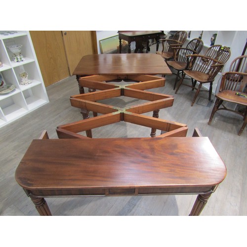6197 - A Georgian mahogany concertina action extending dining table of rounded square form raised upon six ... 