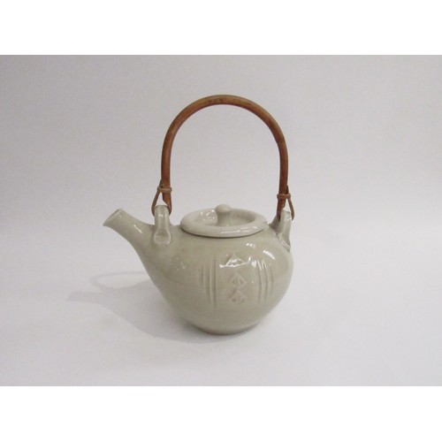 9086 - A pale celadon glazed studio pottery teapot with cane handle. Impressed seal to base for Glen Barron... 