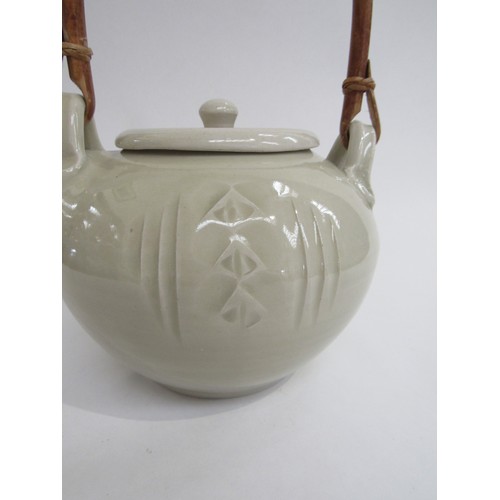 9086 - A pale celadon glazed studio pottery teapot with cane handle. Impressed seal to base for Glen Barron... 