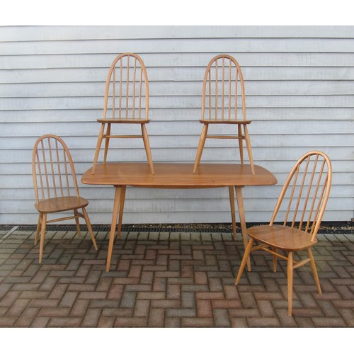 9344 - An Ercol light elm dining table and four high hoop back chairs. Table 152cm x 77cm x 71cm high