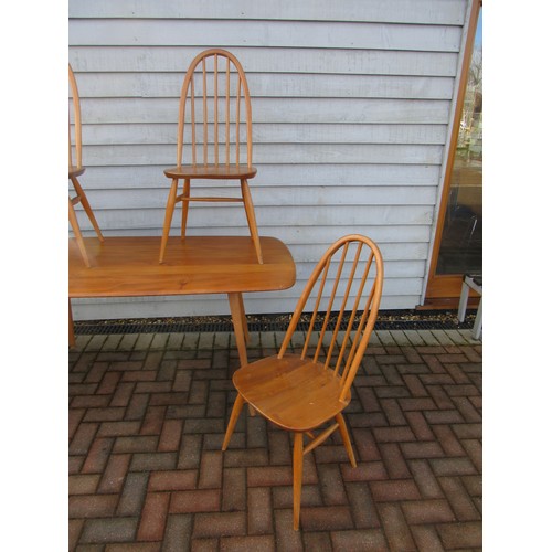 9344 - An Ercol light elm dining table and four high hoop back chairs. Table 152cm x 77cm x 71cm high